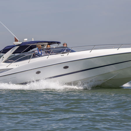 Motor cruiser speeding through the ocean with numerous people onboard
