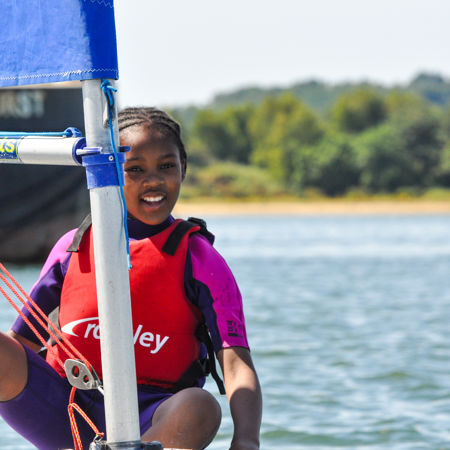 young girl dinghy sailing and smiling